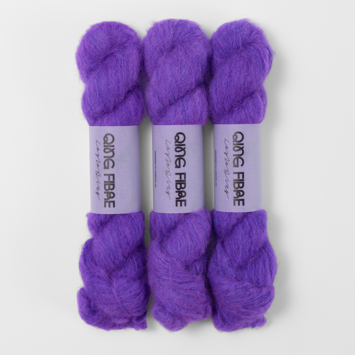 Three labelled hanks of Prince Melted Baby Suri 25g yarn in violet purple.