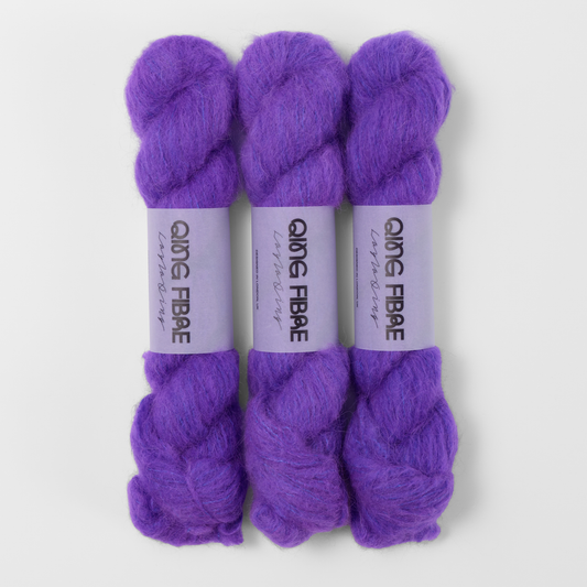 Three labelled hanks of Prince Melted Baby Suri 25g yarn in violet purple.