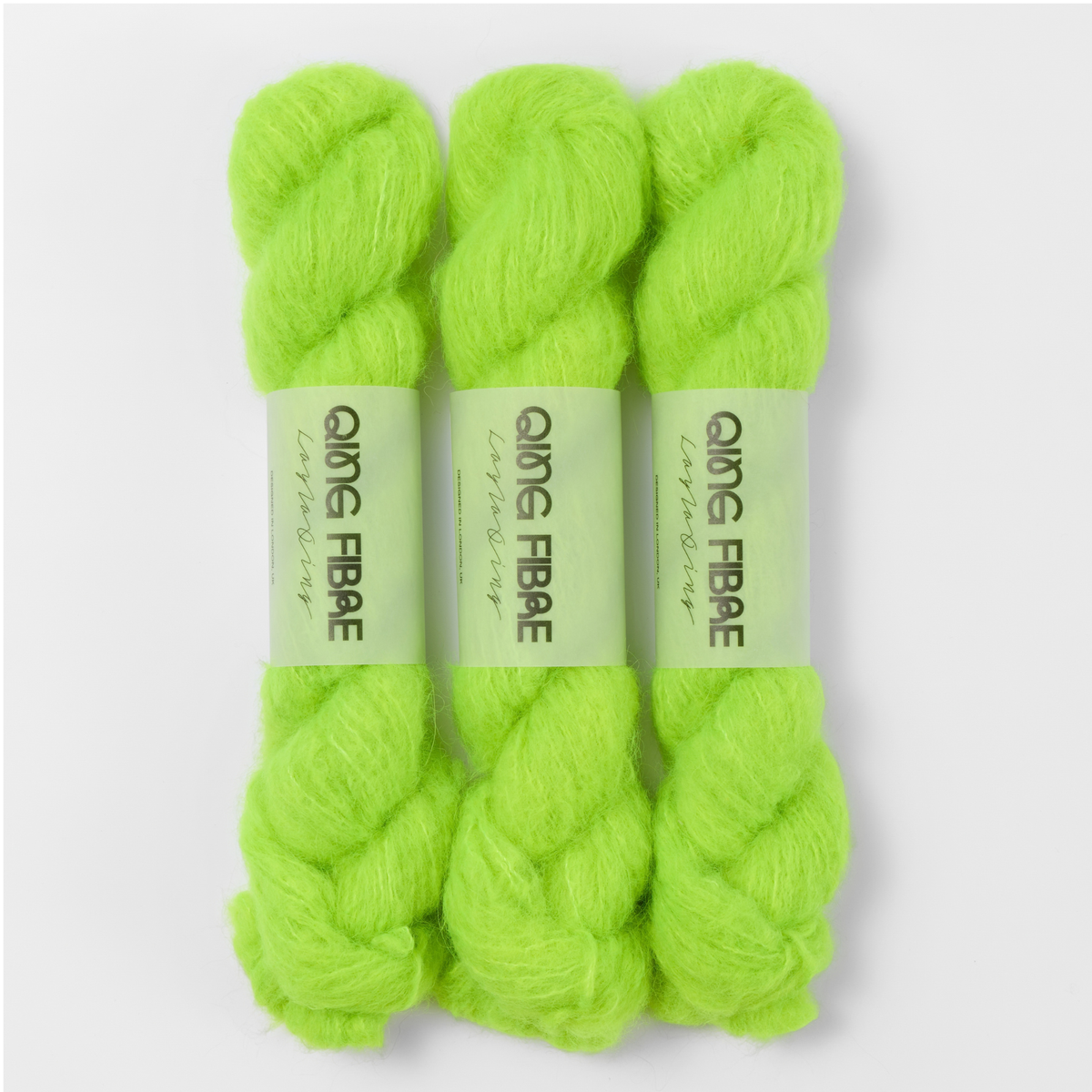 Three labelled hanks of Ninja Turtle Melted Baby Suri 25g yarn in neon green.