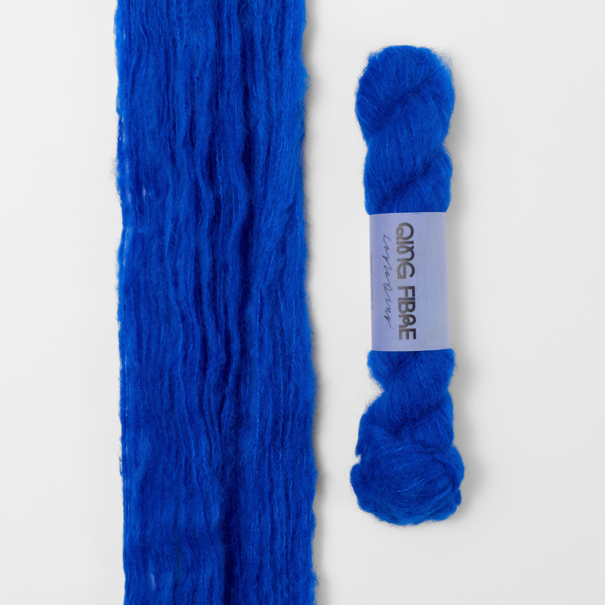 Hero Melted Baby Suri 25g: vivid blue yarn, shown loose beside a labelled hank.