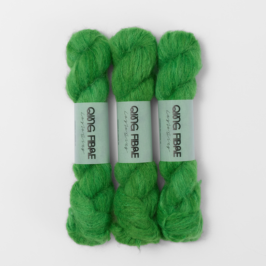 Three labelled hanks of Grass Melted Baby Suri 25g yarn in bright green.