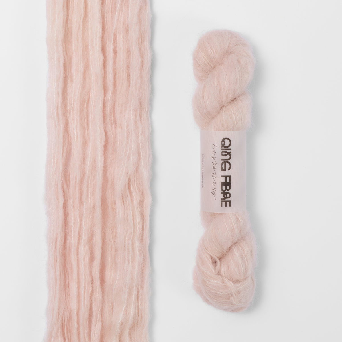 Dust Melted Baby Suri 25g: pale blush pink yarn, shown loose beside a labelled hank.