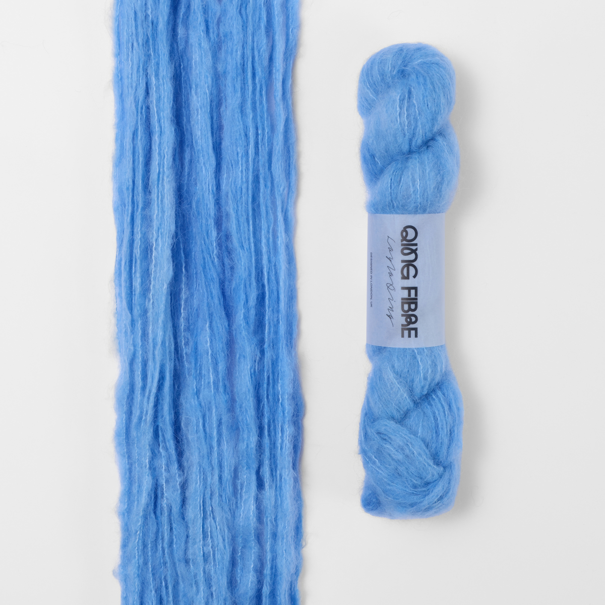 Drift Melted Baby Suri 25g: pale blue yarn, shown loose beside a labelled hank.