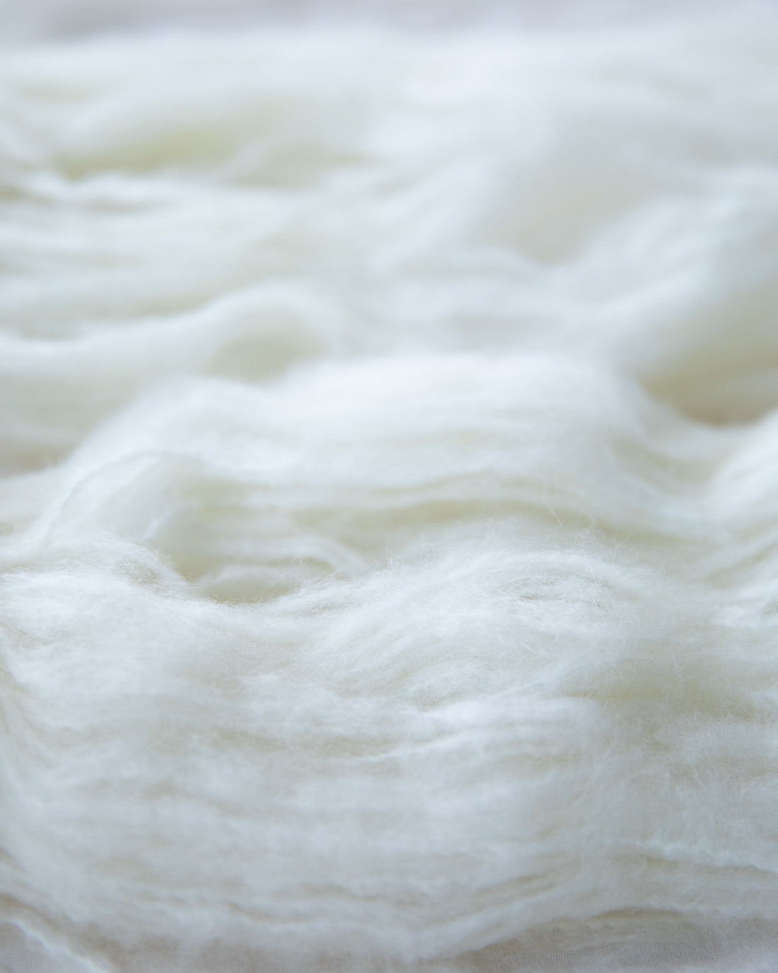 Close-up of soft white wool roving texture for felting and spinning projects