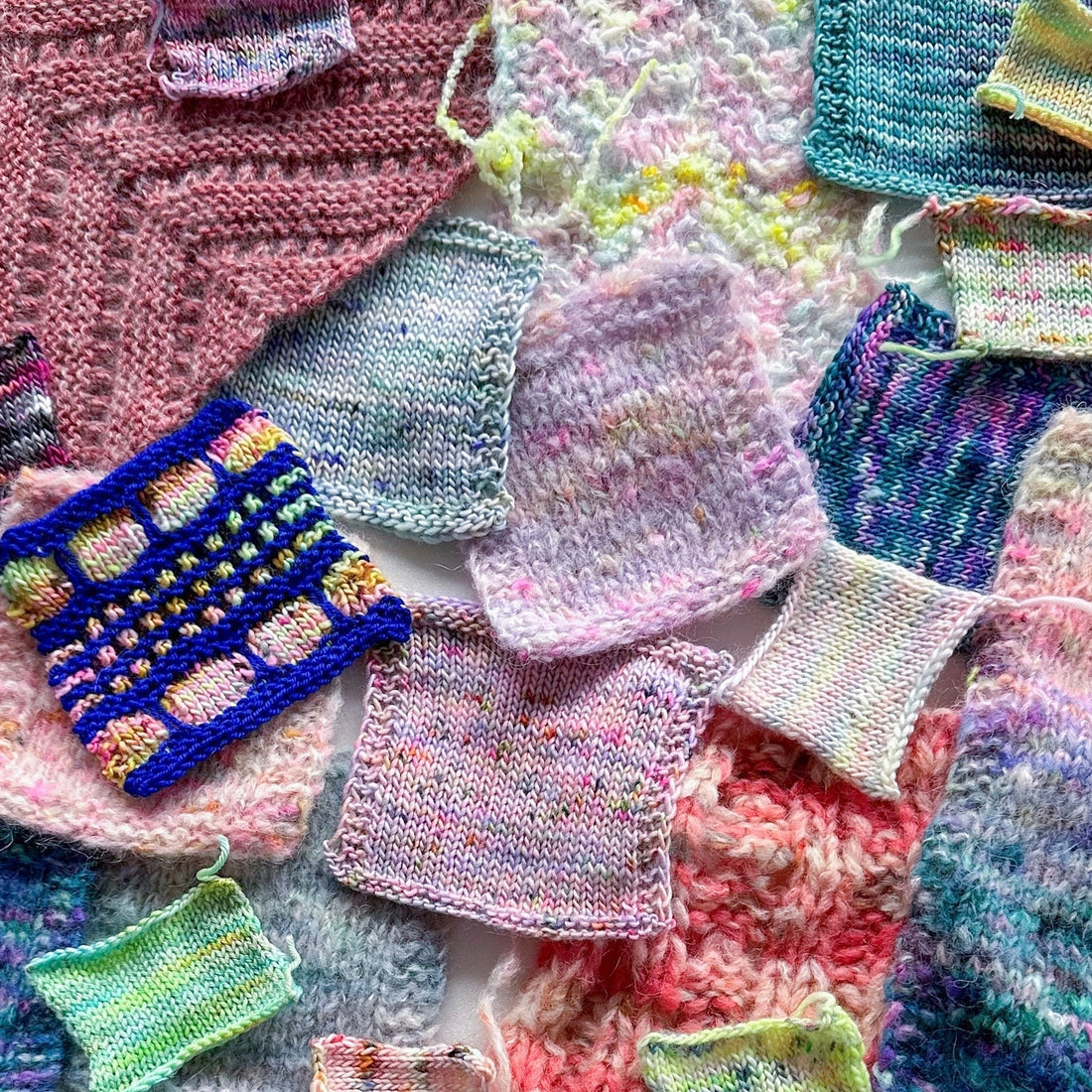 Colorful hand-knit yarn swatches in varying patterns and textures on a flat surface