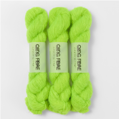 Three labelled hanks of Ninja Turtle Melted Baby Suri 25g yarn in neon green.