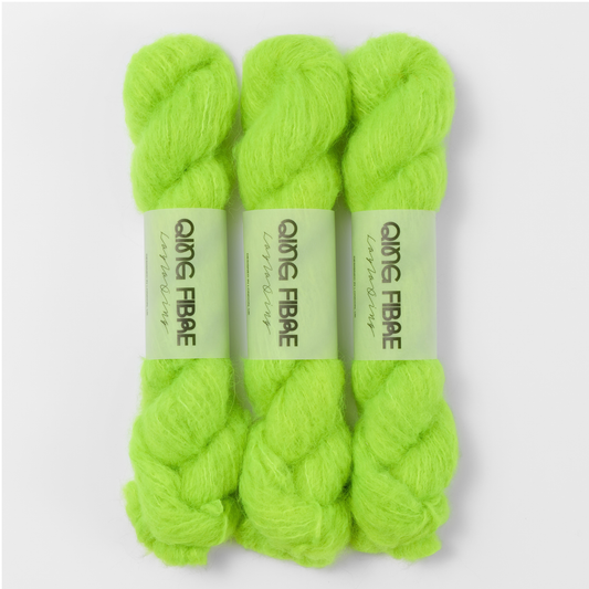 Three labelled hanks of Ninja Turtle Melted Baby Suri 25g yarn in neon green.
