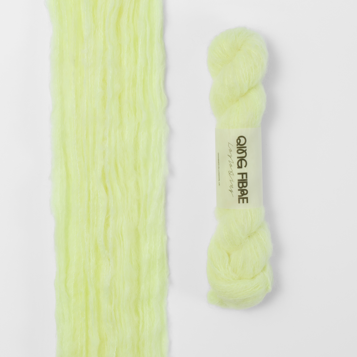 Lightning Melted Baby Suri 25g: pale neon yellow yarn, shown loose beside a labelled hank.