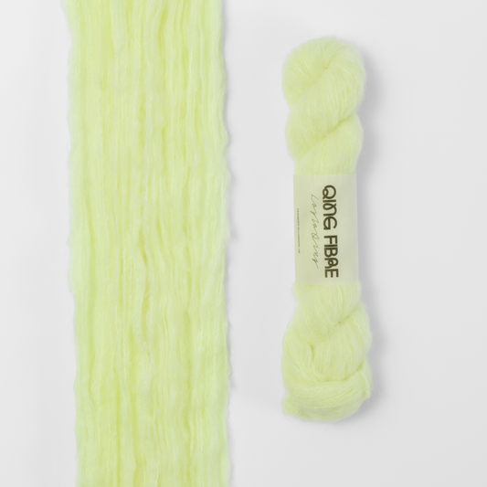 Lightning Melted Baby Suri 25g: pale neon yellow yarn, shown loose beside a labelled hank.