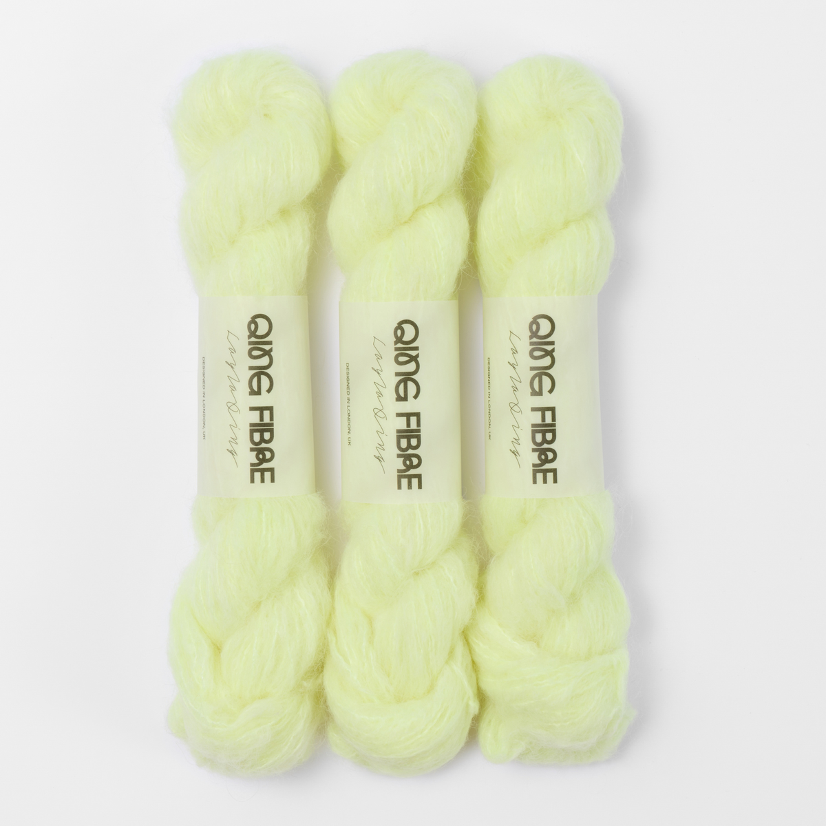 Three labelled hanks of Lightning Melted Baby Suri 25g yarn in pale neon yellow.