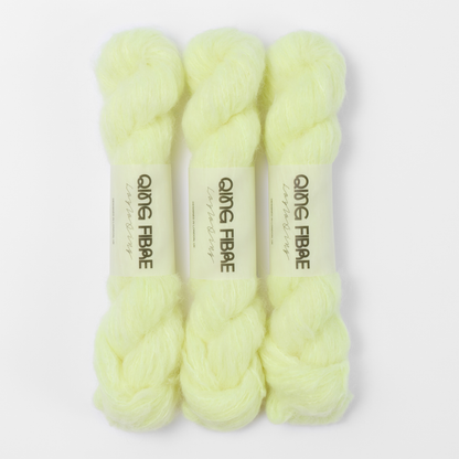 Three labelled hanks of Lightning Melted Baby Suri 25g yarn in pale neon yellow.