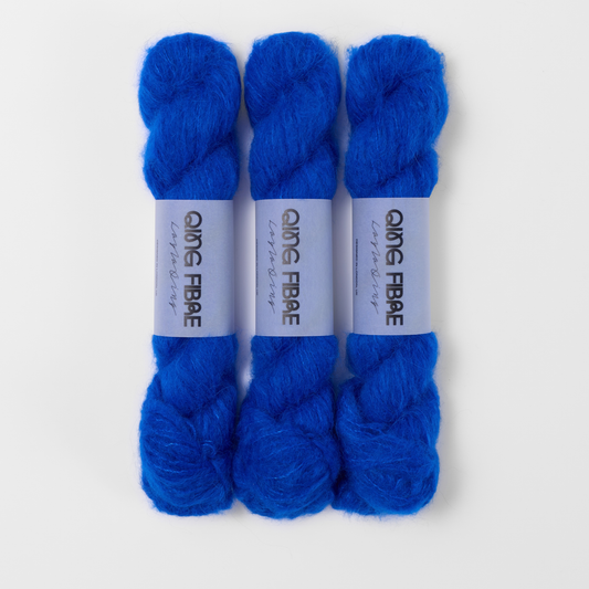 Three labelled hanks of Hero Melted Baby Suri 25g yarn in vivid blue.