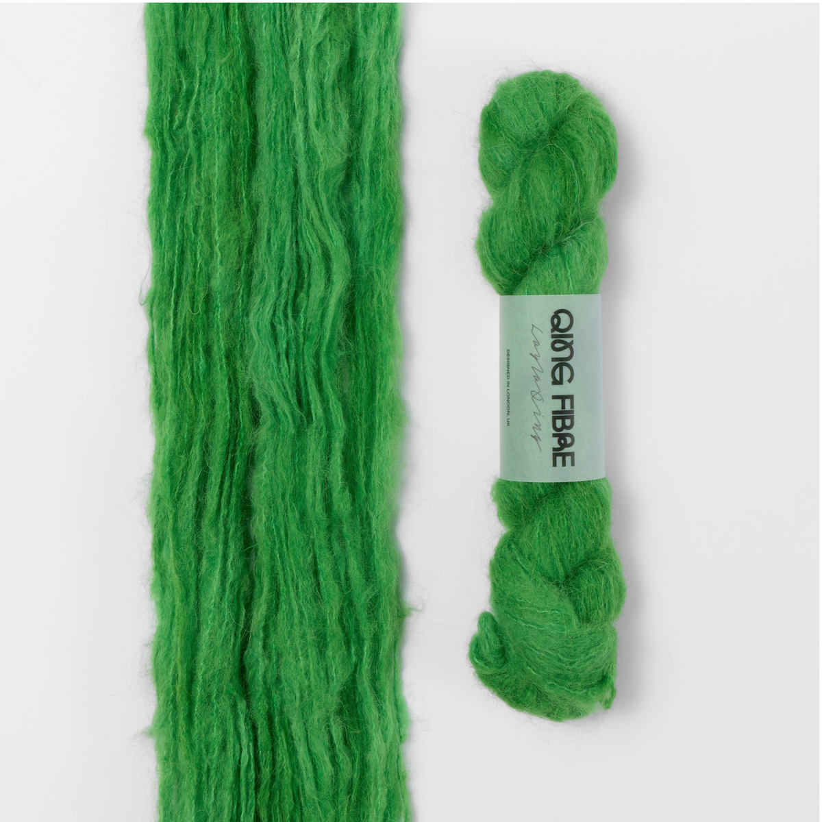 Grass Melted Baby Suri 25g: bright green yarn, shown loose beside a labelled hank.