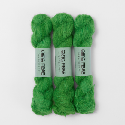 Three labelled hanks of Grass Melted Baby Suri 25g yarn in bright green.