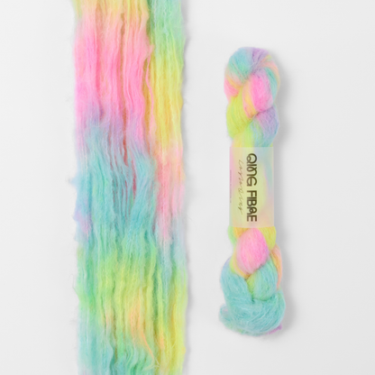 Flying Saucer Melted Baby Suri 25g: bright pink, yellow and turquoise green yarn, shown loose beside a labelled hank.