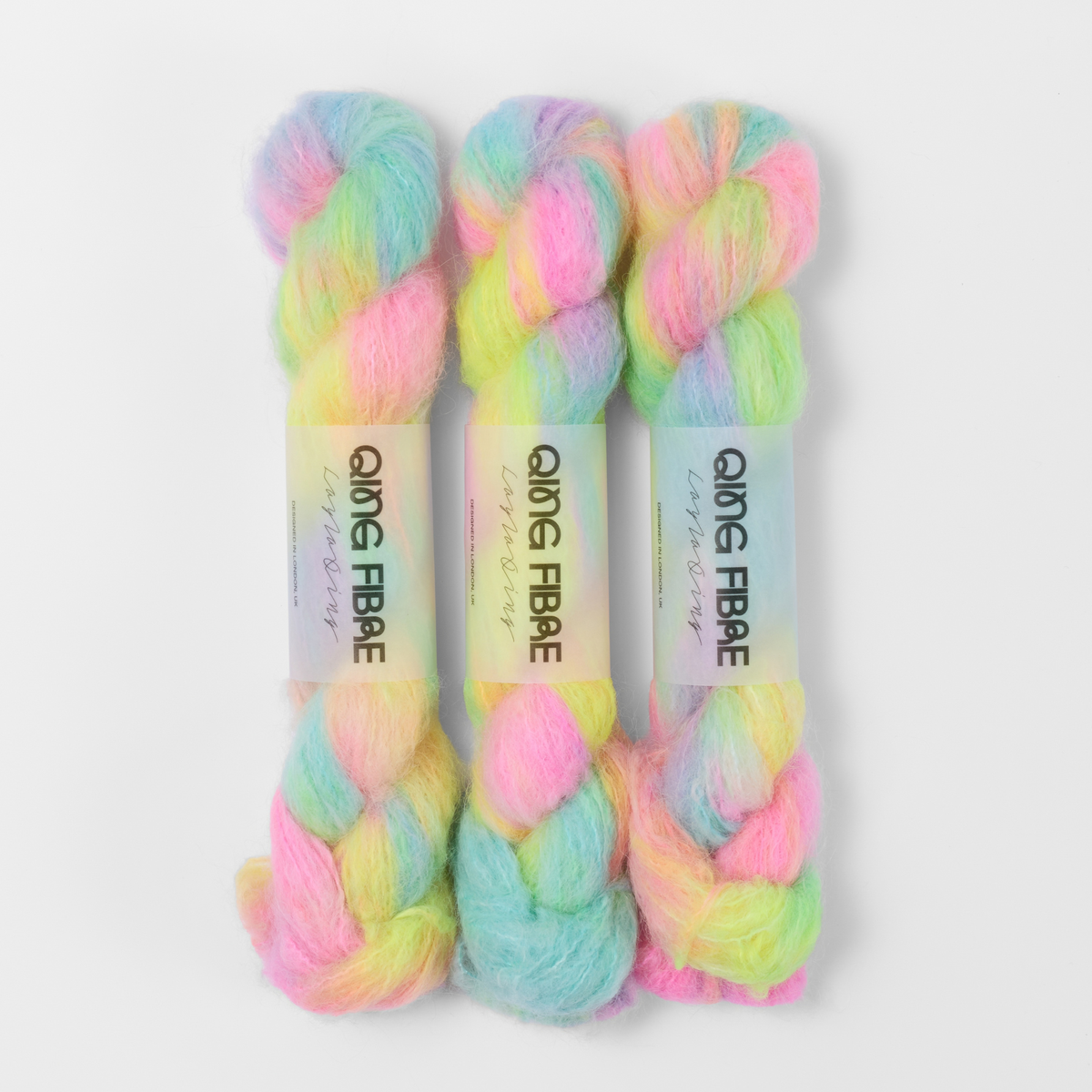 Three labelled hanks of Flying Saucer Melted Baby Suri 25g yarn in bright pink, yellow and turquoise green.