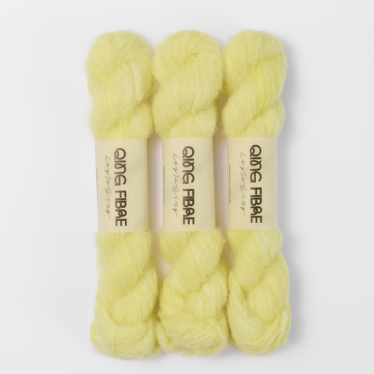 Three labelled hanks of Cocoon Melted Baby Suri 25g yarn in pale yellow.