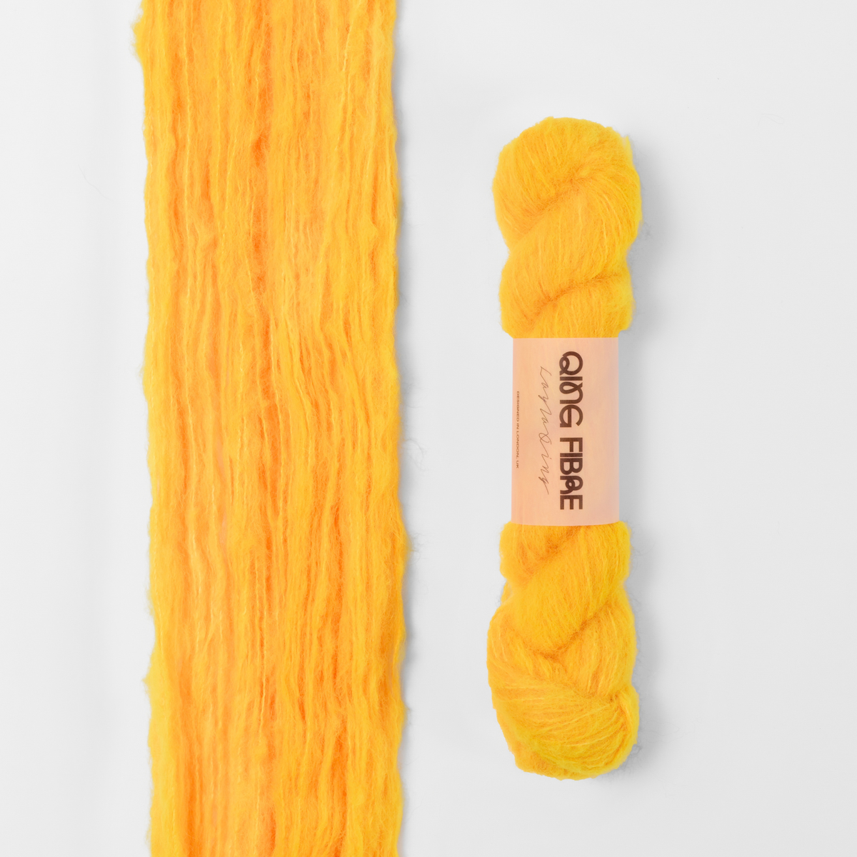Cheese Melted Baby Suri 25g: golden orange yarn, shown loose beside a labelled hank.