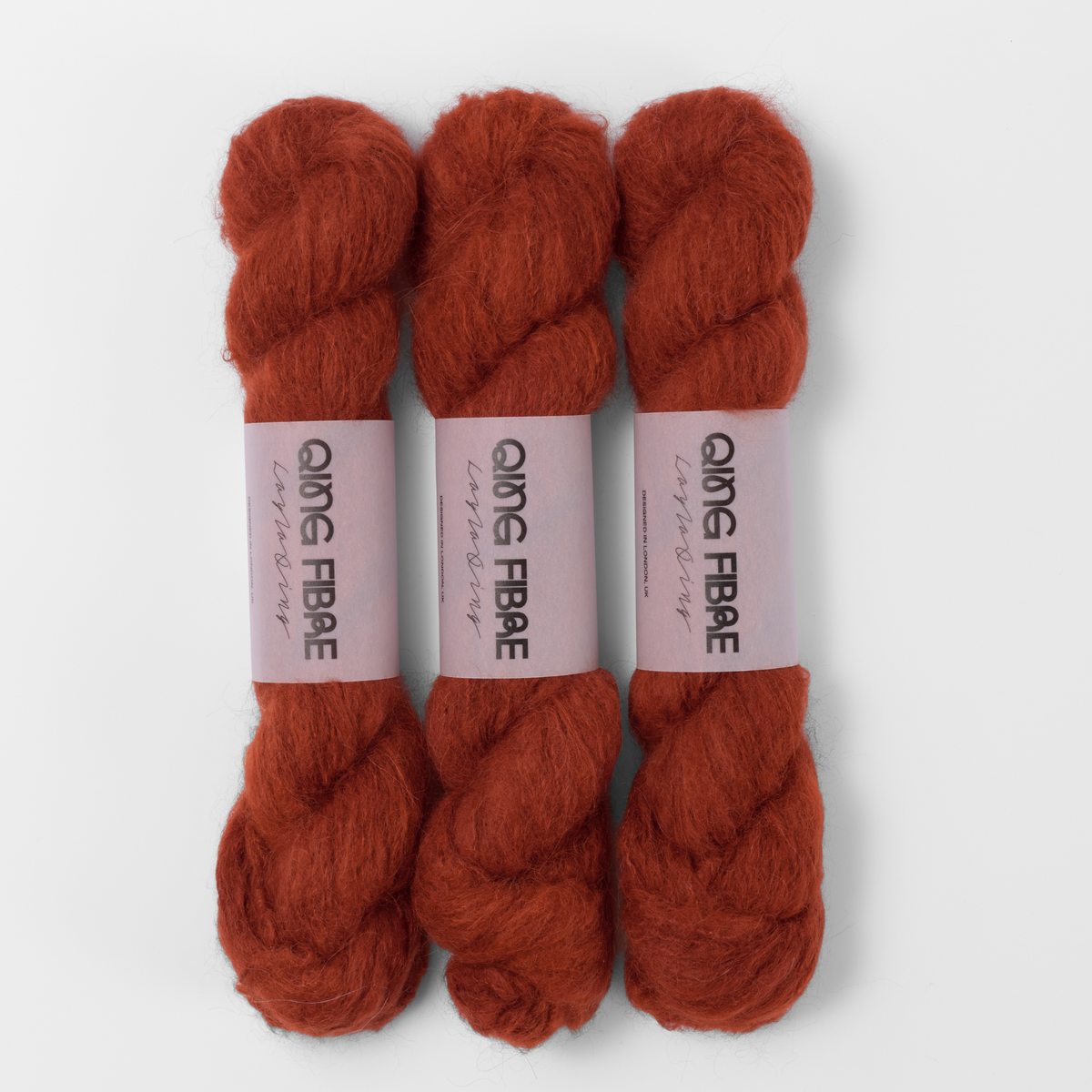 Three labelled hanks of All Hallows Melted Baby Suri 25g yarn in rust red.