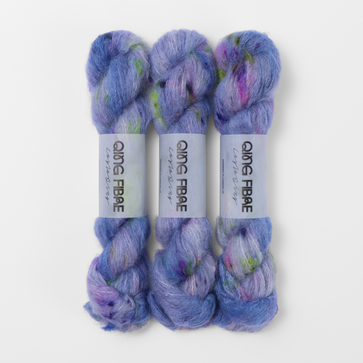 Three labelled hanks of Moon Goddess Melted Baby Suri 25g yarn in lavender with pink and green accents.