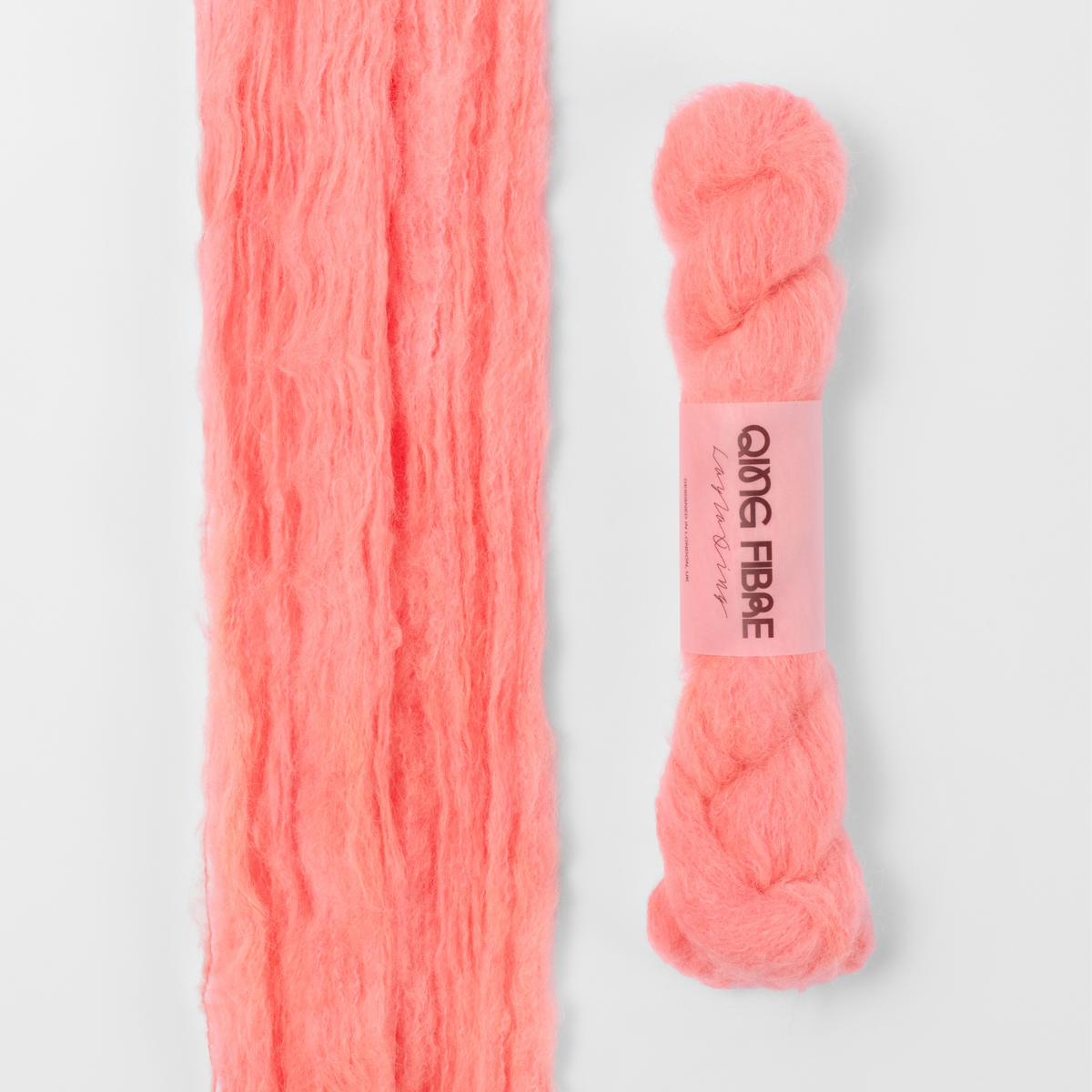 Shrimp Melted Baby Suri 25g: coral orange yarn, shown loose beside a labelled hank.