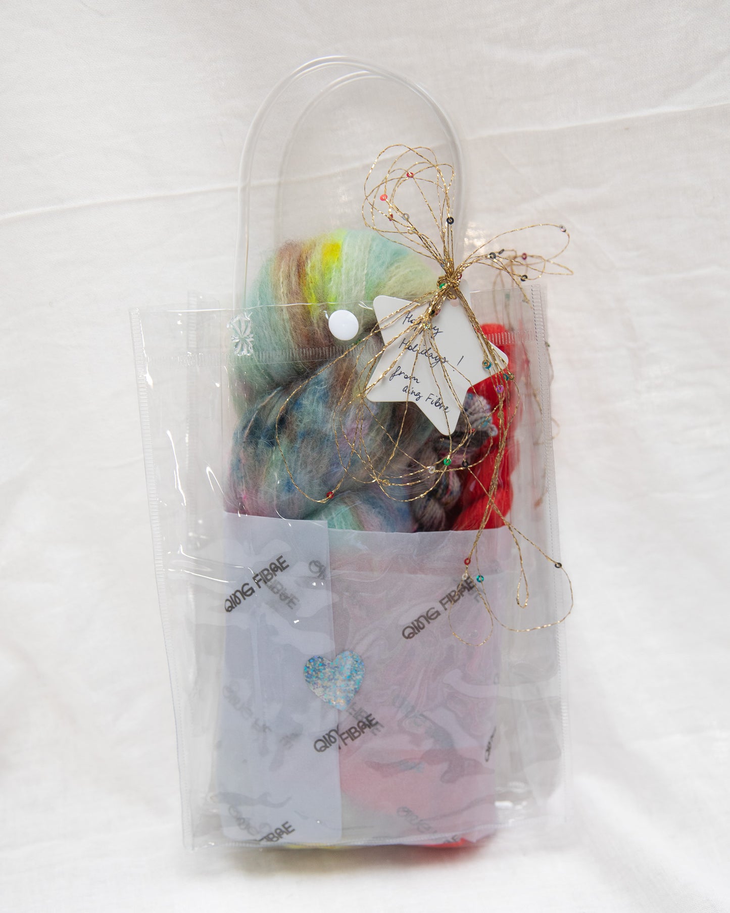 Packaged craft supplies including yarn and tools on a white background