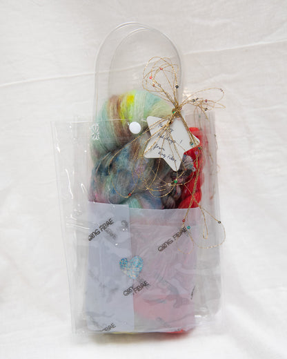 Packaged craft supplies including yarn and tools on a white background
