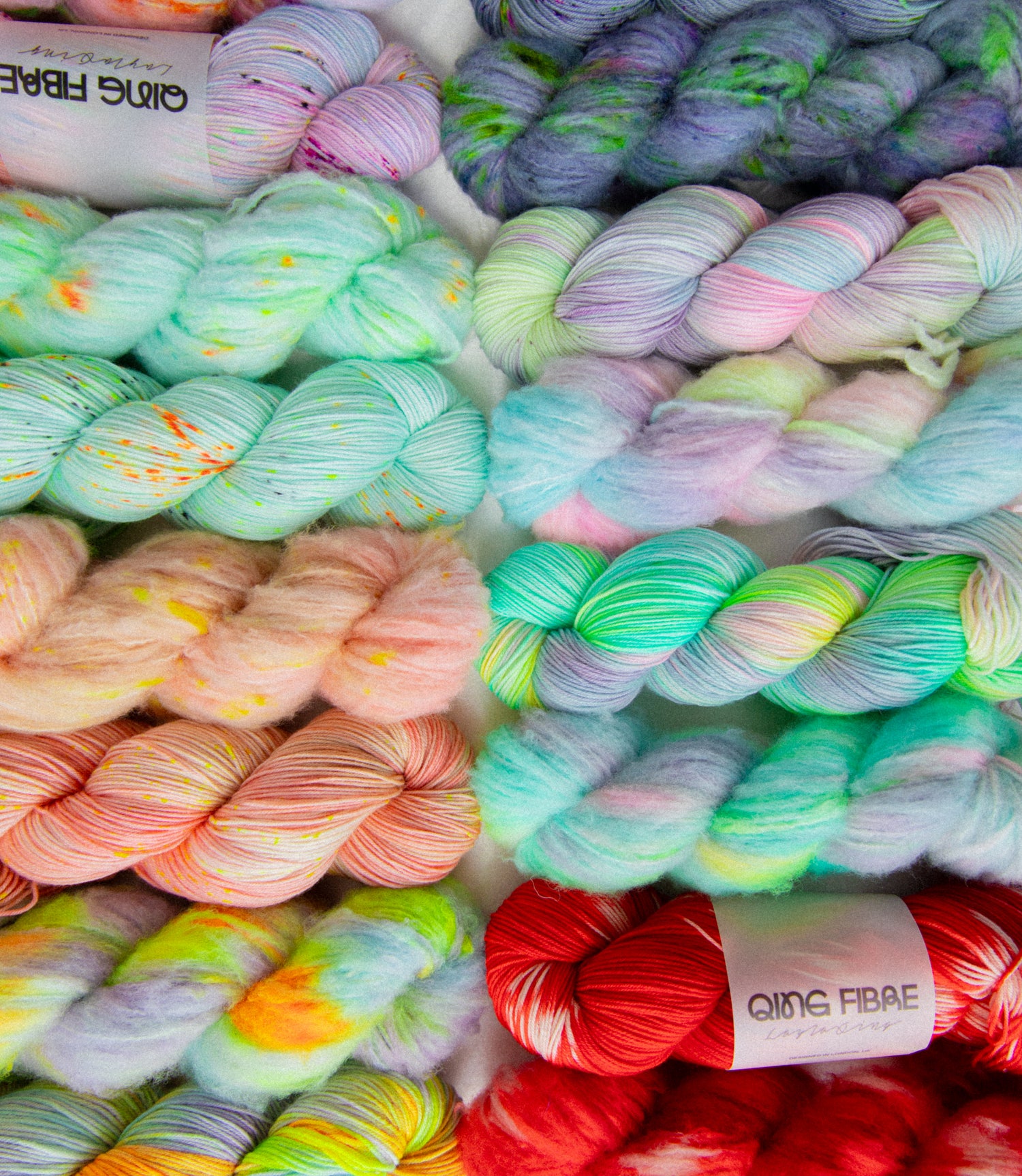 Assorted colorful skeins of yarn with 'Ging Fibre' labels.
