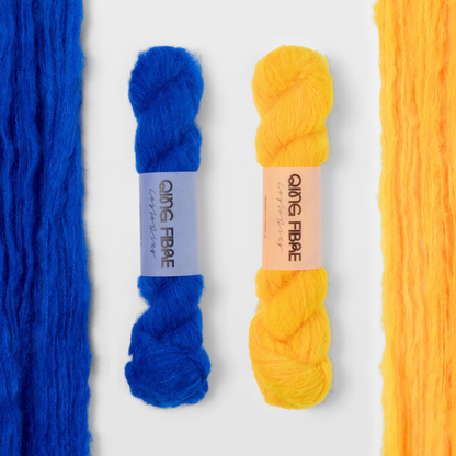 Hero blue and Cheese yellow Melted Baby Suri 25g yarn, with two twisted skeins between the open skeins on a grey background.