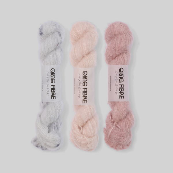 Soft Blush Suri 25g fade set: Platinum, Dust and Soft Clay twisted skeins arranged from silvery grey through pale blush to dusty rose.
